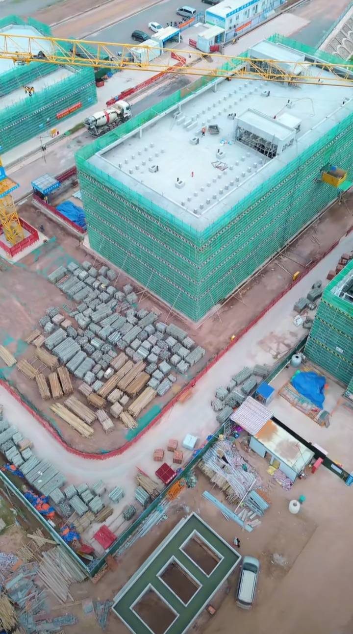 楼体屋面结构完成，材料堆场同塔吊作业面